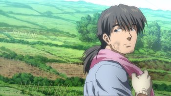 Movie still from “Evangelion: 2.0 You Can (Not) Advance” (2009), directed by Joe Fria – A man standing on top of a lush green hillside; Close Up shot, Over the shoulder angle