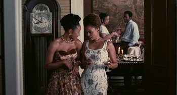 Movie still from “Eve's Bayou” (1997), directed by Kasi Lemmons – Two women are standing in front of each other holding wine glasses; Medium shot, Over the shoulder angle