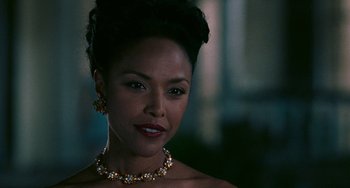 Movie still from “Eve's Bayou” (1997), directed by Kasi Lemmons – A woman wearing a necklace and earrings in front of a window; Close Up shot, Over the shoulder angle