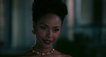 Movie still from “Eve's Bayou” (1997), directed by Kasi Lemmons – A woman wearing a necklace and earrings in front of a window; Close Up shot, Over the shoulder angle
