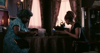 Movie still from “Eve's Bayou” (1997), directed by Kasi Lemmons – Two people sitting at a table with a candle; Medium shot, High angle
