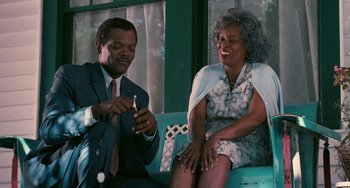 Movie still from “Eve's Bayou” (1997), directed by Kasi Lemmons – An older woman sitting next to an older man holding a cell phone; Medium shot, Low angle