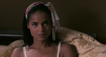 Movie still from “Eve's Bayou” (1997), directed by Kasi Lemmons – A woman sitting on top of a bed wearing a head scarf; Close Up shot, High angle