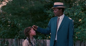 Movie still from “Eve's Bayou” (1997), directed by Kasi Lemmons – A man in a suit and a girl in a leopard print dress; Medium shot, Over the shoulder angle