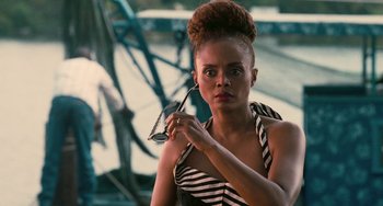 Movie still from “Eve's Bayou” (1997), directed by Kasi Lemmons – A woman holding a pair of sunglasses while standing on top of a bridge; Close Up shot, Over the shoulder angle