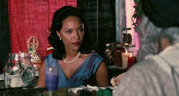 Movie still from “Eve's Bayou” (1997), directed by Kasi Lemmons – A woman sitting at a dinner table with a candle; Close Up shot, Over the shoulder angle