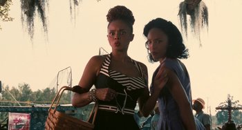 Movie still from “Eve's Bayou” (1997), directed by Kasi Lemmons – Two women standing next to each other holding a basket; Medium shot, Low angle