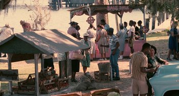 Movie still from “Eve's Bayou” (1997), directed by Kasi Lemmons – A group of people standing around at an outdoor market; Wide shot, High angle