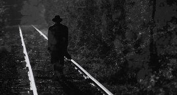 Movie still from “Eve's Bayou” (1997), directed by Kasi Lemmons – A man in a hat is standing on a train track; Wide shot, Low angle