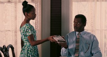 Movie still from “Eve's Bayou” (1997), directed by Kasi Lemmons – A man and a woman are holding a book; Medium shot, Over the shoulder angle