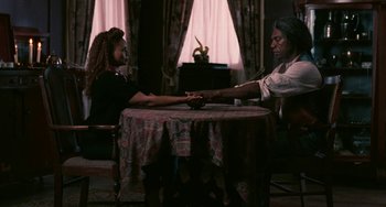 Movie still from “Eve's Bayou” (1997), directed by Kasi Lemmons – A woman sitting at a table with an older man; Medium shot, High angle