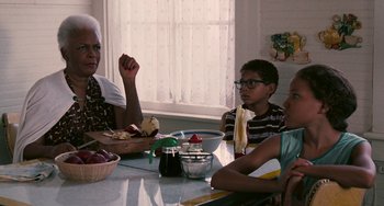 Movie still from “Eve's Bayou” (1997), directed by Kasi Lemmons – A group of people sitting at a table eating food; Medium shot, Over the shoulder angle