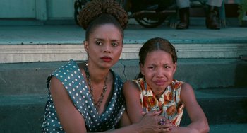 Movie still from “Eve's Bayou” (1997), directed by Kasi Lemmons – Two young women sitting next to each other on the street; Close Up shot, High angle
