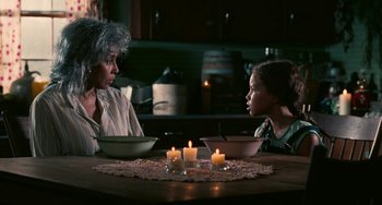 Movie still from “Eve's Bayou” (1997), directed by Kasi Lemmons – Two people sitting at a dinner table with candles; Medium shot, Over the shoulder angle