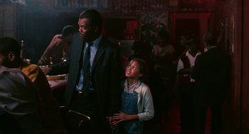 Movie still from “Eve's Bayou” (1997), directed by Kasi Lemmons – A man and a young girl standing in front of a bar; Medium shot, Over the shoulder angle