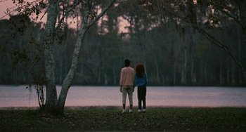 Movie still from “Eve's Bayou” (1997), directed by Kasi Lemmons – Two people standing next to each other in front of a body of water; Wide shot, Over the shoulder angle
