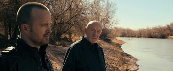 Movie still from “El Camino: A Breaking Bad Movie” (2019), directed by Vince Gilligan – An older man standing in front of a body of water; Close Up shot, Over the shoulder angle