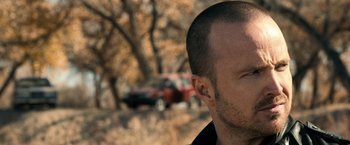 Movie still from “El Camino: A Breaking Bad Movie” (2019), directed by Vince Gilligan – A man's head with trees in the background; Close Up shot, Over the shoulder angle