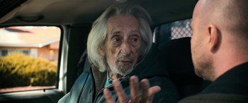 Movie still from “El Camino: A Breaking Bad Movie” (2019), directed by Vince Gilligan – An old man with long white hair and a beard; Close Up shot, Over the shoulder angle