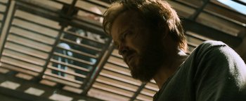 Movie still from “El Camino: A Breaking Bad Movie” (2019), directed by Vince Gilligan – A person with a beard; Close Up shot, Over the shoulder angle