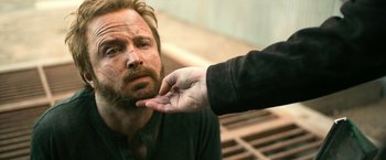 Movie still from “El Camino: A Breaking Bad Movie” (2019), directed by Vince Gilligan – A man with a beard is looking at another man's hand; Close Up shot, Over the shoulder angle