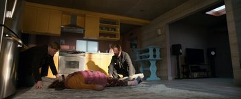 Movie still from “El Camino: A Breaking Bad Movie” (2019), directed by Vince Gilligan – A man sitting on the ground next to a woman; Wide shot, Low angle