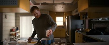 Movie still from “El Camino: A Breaking Bad Movie” (2019), directed by Vince Gilligan – A man in a gray shirt is stirring something in a pot; Medium shot, Low angle