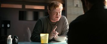Movie still from “El Camino: A Breaking Bad Movie” (2019), directed by Vince Gilligan – A man sitting at a table with a bowl of cereal; Medium shot, Over the shoulder angle