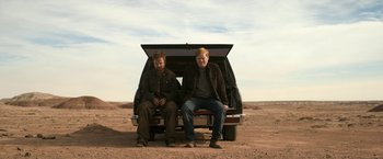 Movie still from “El Camino: A Breaking Bad Movie” (2019), directed by Vince Gilligan – Two men sitting in the back of a truck; Wide shot, Low angle