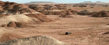 Movie still from “El Camino: A Breaking Bad Movie” (2019), directed by Vince Gilligan – A car is parked in the middle of the desert; Extreme Wide shot, High angle
