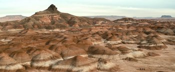 Movie still from “El Camino: A Breaking Bad Movie” (2019), directed by Vince Gilligan – A view of a desert landscape with a mountain in the background; Extreme Wide shot, High angle