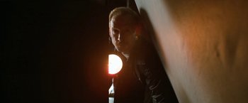 Movie still from “El Camino: A Breaking Bad Movie” (2019), directed by Vince Gilligan – A man with a light in his hand is standing in a dark room; Close Up shot, Low angle