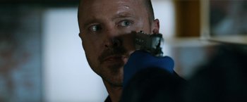 Movie still from “El Camino: A Breaking Bad Movie” (2019), directed by Vince Gilligan – A person holding a gun in their hand; Close Up shot, Low angle