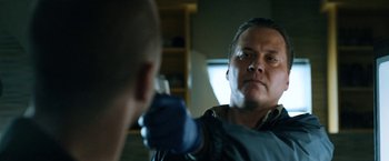 Movie still from “El Camino: A Breaking Bad Movie” (2019), directed by Vince Gilligan – A man is holding something in front of a mirror; Close Up shot, Low angle