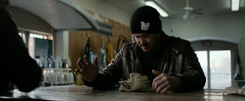 Movie still from “El Camino: A Breaking Bad Movie” (2019), directed by Vince Gilligan – A man sitting at a table with a stack of money in front of him; Close Up shot, Over the shoulder angle