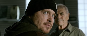 Movie still from “El Camino: A Breaking Bad Movie” (2019), directed by Vince Gilligan – A person wearing a hat; Close Up shot, Low angle