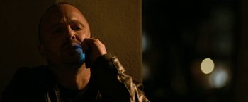 Movie still from “El Camino: A Breaking Bad Movie” (2019), directed by Vince Gilligan – A bald headed man talking on a cell phone; Close Up shot, Low angle