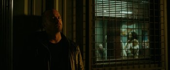 Movie still from “El Camino: A Breaking Bad Movie” (2019), directed by Vince Gilligan – A man standing in front of a window looking out; Medium shot, Over the shoulder angle