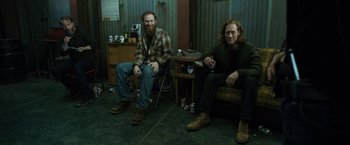 Movie still from “El Camino: A Breaking Bad Movie” (2019), directed by Vince Gilligan – A couple of men sitting next to each other on a chair; Wide shot, High angle
