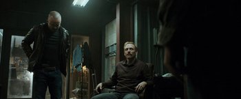 Movie still from “El Camino: A Breaking Bad Movie” (2019), directed by Vince Gilligan – A man sitting in a chair in front of a mirror; Medium shot, Over the shoulder angle