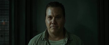 Movie still from “El Camino: A Breaking Bad Movie” (2019), directed by Vince Gilligan – A person wearing a green shirt; Close Up shot, Low angle