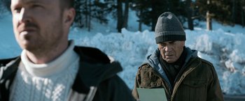 Movie still from “El Camino: A Breaking Bad Movie” (2019), directed by Vince Gilligan – A man wearing a winter hat and a jacket; Close Up shot, Over the shoulder angle