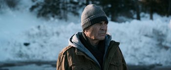 Movie still from “El Camino: A Breaking Bad Movie” (2019), directed by Vince Gilligan – An older man wearing a hat and a jacket; Close Up shot, Over the shoulder angle