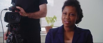Movie still from “Everybody Loves Jeanne” (2022), directed by Céline Devaux – A woman sitting in front of a man in a black shirt; Close Up shot, Over the shoulder angle