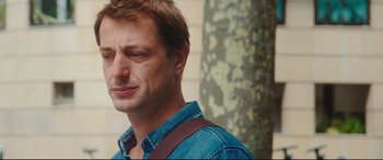 Movie still from “Everybody Loves Jeanne” (2022), directed by Céline Devaux – A person wearing a blue shirt; Close Up shot, Over the shoulder angle
