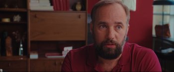 Movie still from “Everybody Loves Jeanne” (2022), directed by Céline Devaux – A man with a goatee and a beard looking at the camera; Close Up shot, Over the shoulder angle