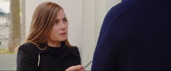 Movie still from “Everybody Loves Jeanne” (2022), directed by Céline Devaux – A woman holding a pair of scissors in front of a mirror; Close Up shot, Over the shoulder angle