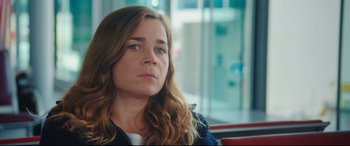 Movie still from “Everybody Loves Jeanne” (2022), directed by Céline Devaux – A person sitting in a chair; Close Up shot, Over the shoulder angle