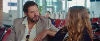 Movie still from “Everybody Loves Jeanne” (2022), directed by Céline Devaux – A man and a woman sitting in a waiting room; Medium shot, Over the shoulder angle