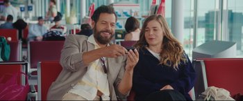 Movie still from “Everybody Loves Jeanne” (2022), directed by Céline Devaux – A man and a woman looking at a cell phone; Medium shot, Over the shoulder angle